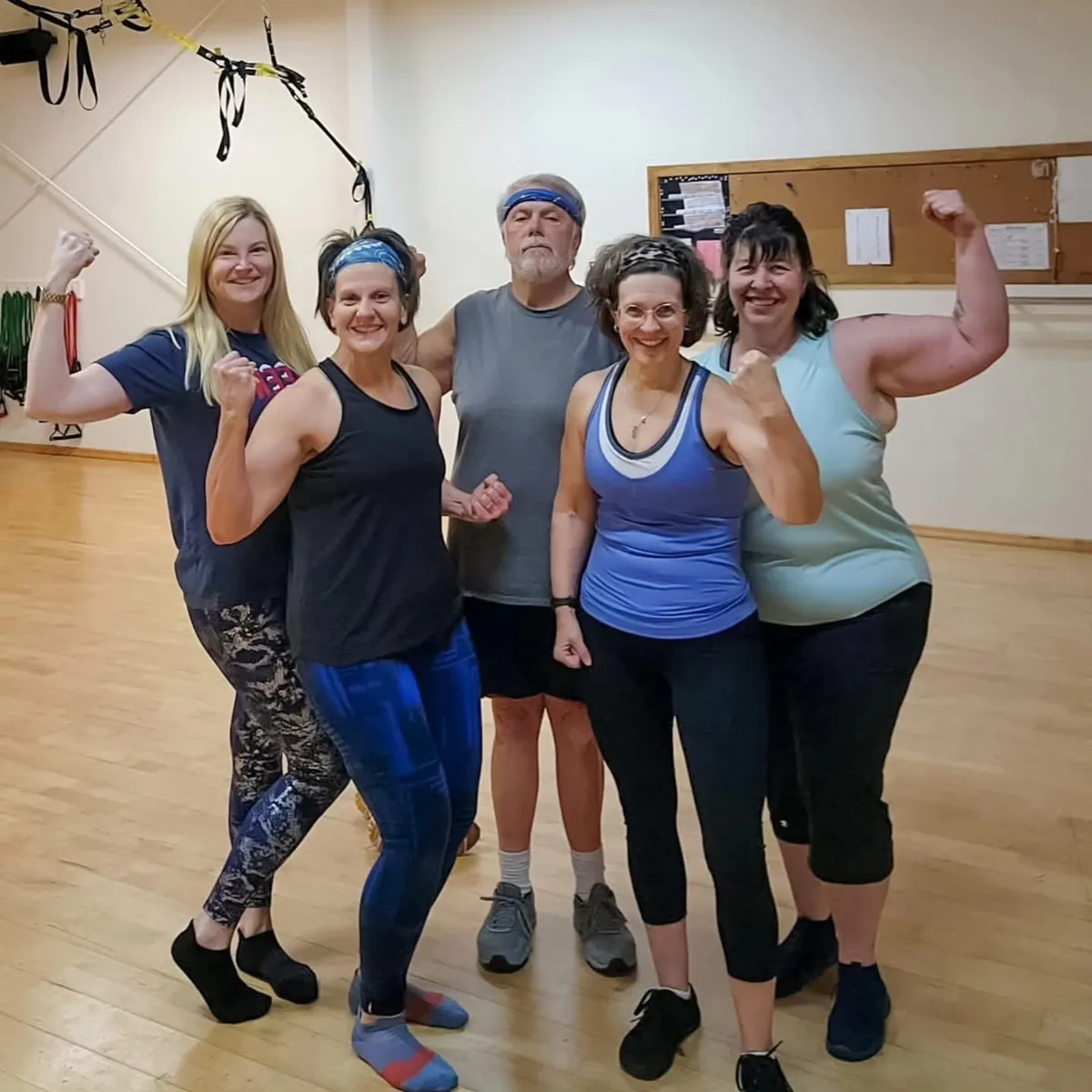 Five members flexing together after a group class at Sara's Health and Fitness in Edgerton, WI